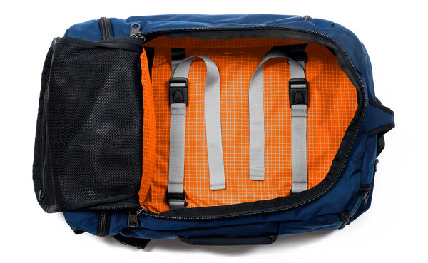 A Techonaut 30 with a Deep Blue (dark blue) exterior with Zest (orange with white grid pattern) 200 Halcyon interior.